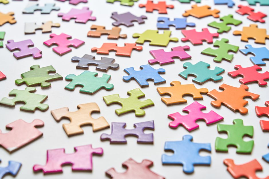 Peças de puzzle coloridas espalhadas sobre uma superfície clara